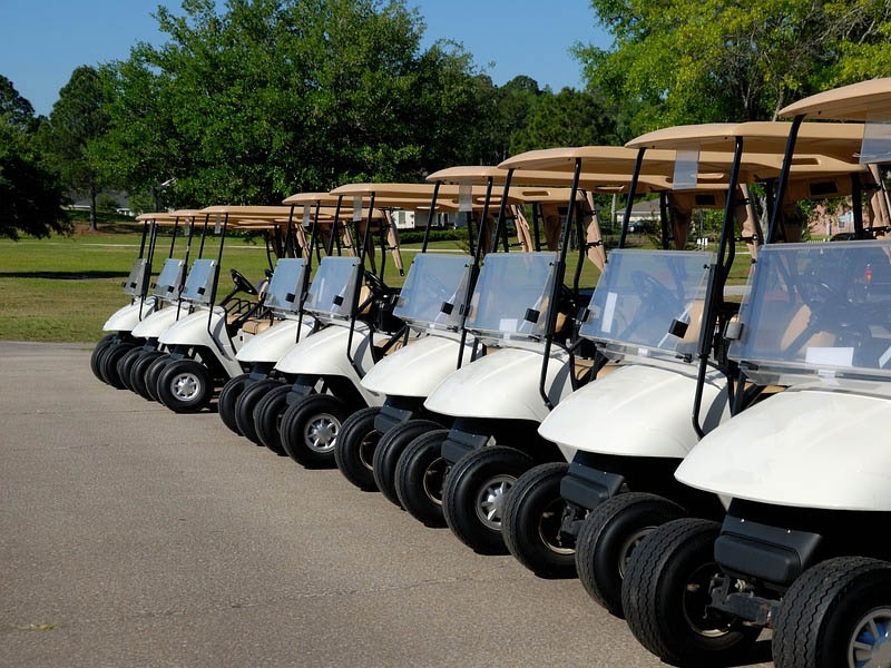 Row of golf carts lined up and ready for players near the golf course staging area.